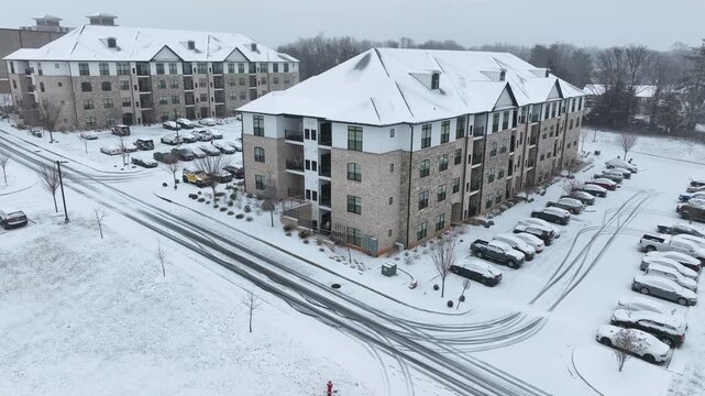 Snowy american townhouse with parking cars on cold winter day. Aerial view. New housing area in suburb of Lynchburg, Virginia. Rising shot. Modern architecture homes.