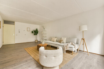 A beautifully designed modern living room featuring minimalist furniture, a cozy rug, greenery, and...