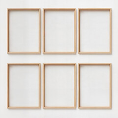 Fototapeta premium Six blank wooden frames arranged symmetrically on a white wall.