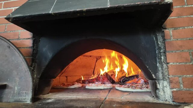 timelapse de pizzas qui montent en cuisson dans le four &agrave; bois de la pizzeria 