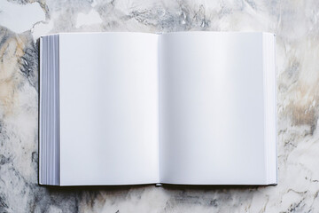 open blank book with white pages resting on light marble surface in soft top down lighting