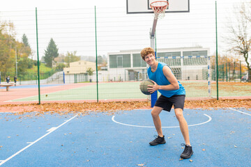 Male basketball player with ball in his hands ready to play game on outside basketball court....