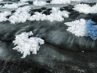 A captivating black and white photograph shows delicate snowflakes on the ground, highlighting winters beauty in monochrome and capturing the essence of freezing weather