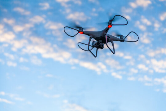RPA drone hovering in clouded sky at dusk