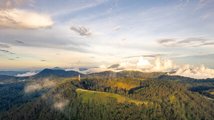 Mount Inerie, the highest volcano in Flores, Indonesia, rises majestically with its perfect cone shape. Captured at sunrise, this aerial view showcases its breathtaking beauty and lush surroundings.