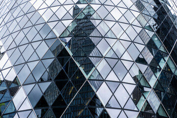 Mirrored cityscape with distorted high-rise reflections on a modern glass building.
