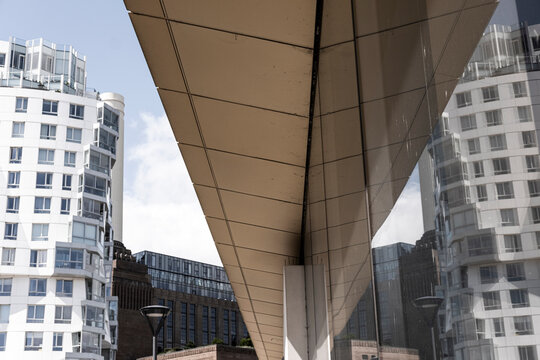 Low-angle view of a modern overhang with skyscrapers in the background.