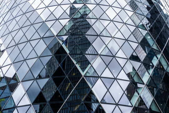 Mirrored cityscape with distorted high-rise reflections on a modern glass building.