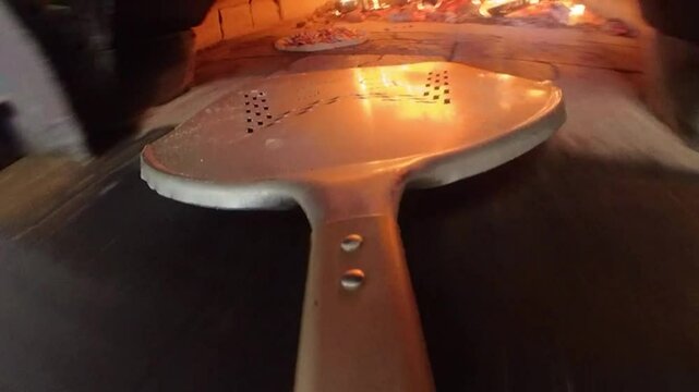 Pizza Jambon champignons et fromage (reine) ins&eacute;r&eacute;e dans le four &agrave; bois avec la pelle &agrave; pizza en mode immersif | POV