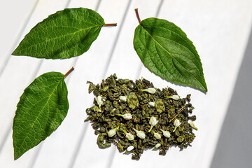 Green tea with jasmine petals on white background