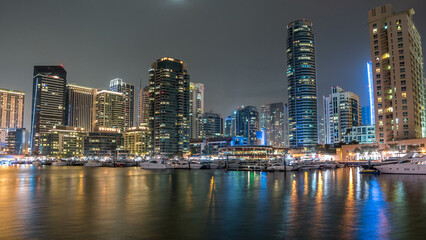 Obraz premium Dubai Marina towers and yacht in Dubai at night timelapse hyperlapse