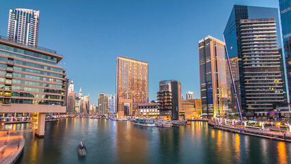 Naklejka premium Dubai Marina towers and canal in Dubai day to night timelapse