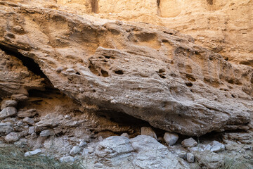 Rough, weathered rock texture. Eroded boulder against canyon wall.