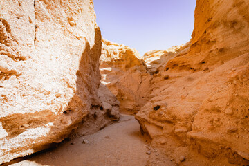 Sunlit, winding path in narrow Kal Jeni canyon in Iran, the Middle East. Towering rock walls.