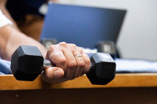 Man exercising wrist with small weights