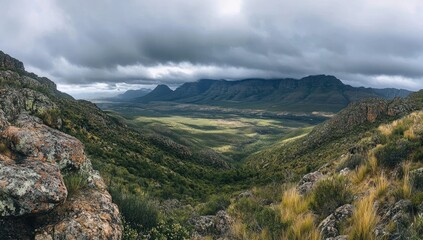 Naklejka premium Mountain valley vista under a dramatic sky