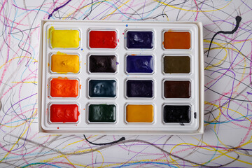 box of watercolor paints on paper background, top view