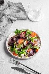 Vegetable salad (Greek salad) with cherry tomatoes, feta cheese, lettuce, olives and red onion in a plate