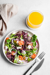 Vegetable salad (Greek salad) with tomatoes, cheese, lettuce, olives and onion in a plate