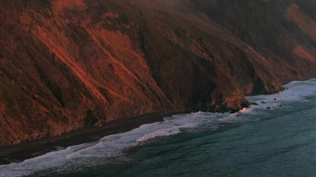USAL Beach Campground Northern California aerial drone bluffs cliffside mountain rocky rugged remote coast vibrant sunset Sinkyone Wilderness waves crashing surf swell circle right motion