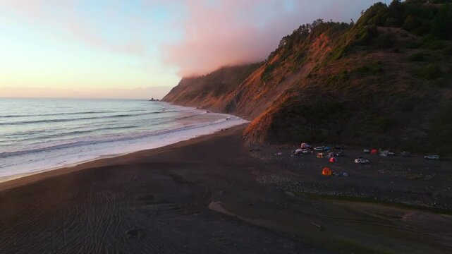 Northern California camping USAL Beach Campground waves crashing bluffs cliffside mountain rocky rugged remote coast aerial drone vibrant sunset Sinkyone Wilderness surf swell black sand forward up