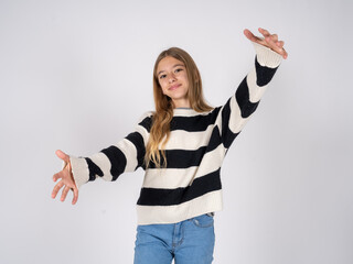 beautiful teen girl wearing striped sweater looking at the camera smiling with open arms for hug. Cheerful expression embracing happiness.