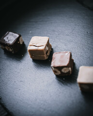 Stimmungsvolle Schokopralinen auf schwarzer Schieferplatte – Dunkler Genuss