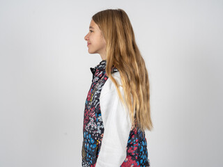 Profile portrait of nice beautiful teen girl wearing colorful vest look empty space toothy smile