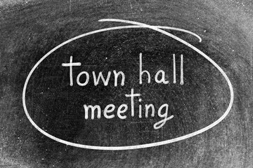 White chalk hand writing in word town hall meeting and circle shape on blackboard background
