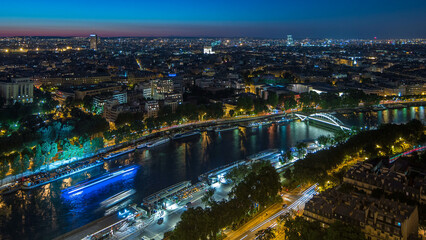Aerial night timelapse view of Paris City and Seine river shot on the top of Eiffel Tower