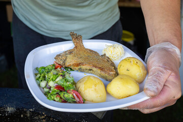 Fish dish - fried flatfish with boiled potatoes and butter. Fried flounder fish with potato and vegetable salad. 