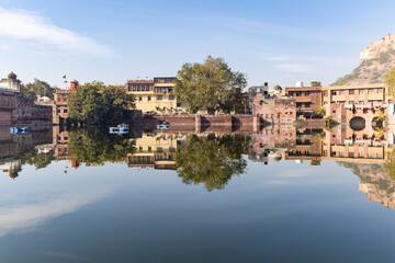 pristine calm lake with water reflection of vintage architecture around at morning