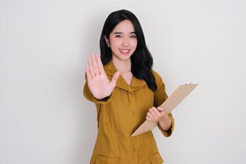 Female Indonesia civil servant smiling while doing stop hand gesture sign