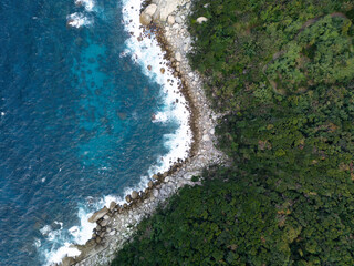 Obraz premium A breathtaking aerial view showcasing the lush coastline beautifully meeting the turquoise waters
