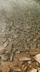 Rain falling on rocky lake shore in high tatras mountains, slovakia