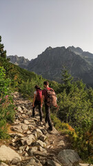 Hikers walking on rocky path in high tatras mountains