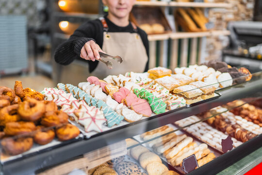 Baker arranging christmas cookies and pastries in display case
