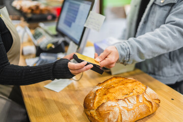 Customer paying with contactless card at bakery shop counter