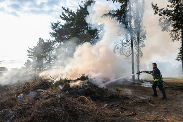 The firefighter is fighting the fire.