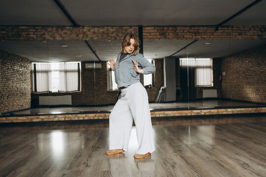 Dancer performs contemporary moves in spacious studio with wooden floors