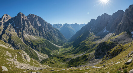Fototapeta premium Majestic mountains rise over a lush green valley in the Italian Alps, bathed in sunlight.
