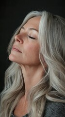 A woman with long gray hair is looking up at the camera