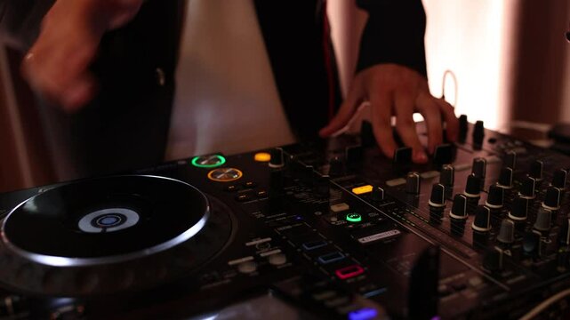 DJ playing music on the console at a disco