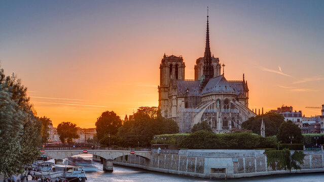 Rear view of Notre Dame De Paris cathedral at sunset with sun in the frame timelapse.
