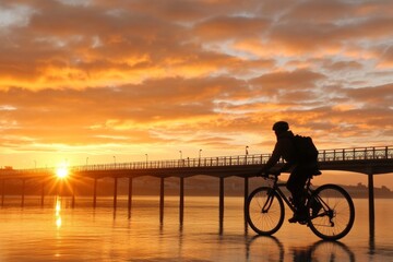Fototapeta premium Bicyclist enjoys sunset ride along pier reflecting vibrant colors in the evening sky