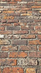 Obraz premium Close-up of a brick wall featuring traditional red bricks with texture and character