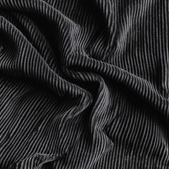 Naklejka premium Black corduroy fabric with natural wrinkles and folds displaying soft texture and depth ideal for fashion and textile industry applications 