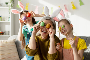 Grandmother and Granddaughters holding Easter Eggs over their Eyes
