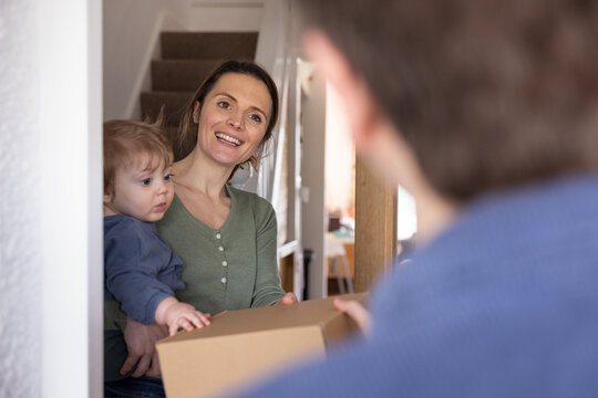 Mom Smiling with Baby receiving a home delivery