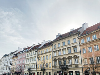 Obraz premium Historic architecture and street scene in Warsaw, Poland with people strolling